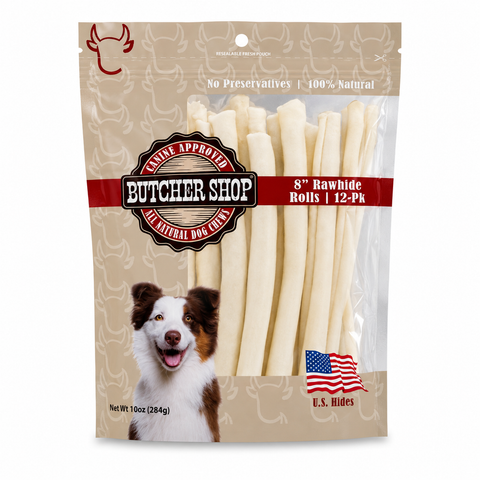 A package of butcher shop 8 inch rawhide dog treats on a plain white background. The packaging is beige with a dog illustration, a red banner, and a clear window showing the off-white rawhide treats inside.