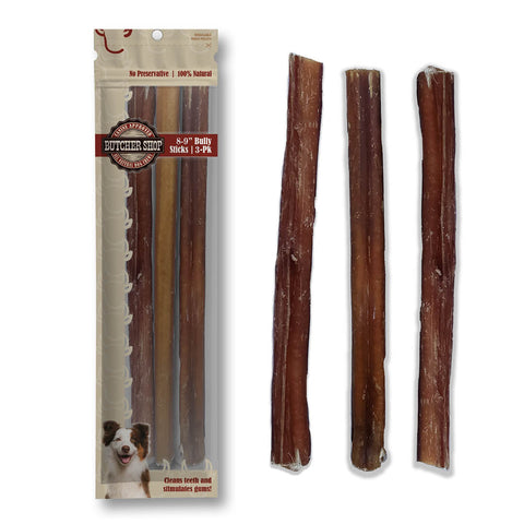 Three natural dog bully sticks shown next to their retail packaging. The packaging is a clear plastic sleeve with a cardboard header, featuring a dog illustration and text for 'Proudly Owned' and 'Bully Stick'.