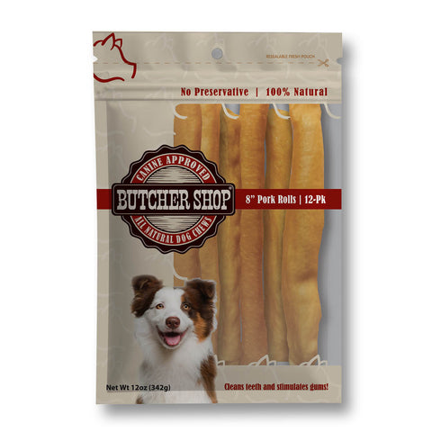 A 12-pack of Butcher Shop 8" Pork Rolls dog treats in a resealable stand-up pouch. The packaging features a brown and beige design with a dog illustration, a red and black logo, and a photo of a brown and white dog.