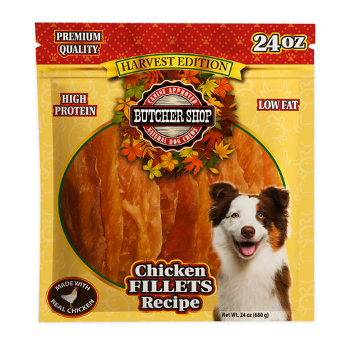 A 24 oz package of Butcher Shop Harvest Edition Natural Dog Chews, Chicken Fillets Recipe. The packaging is yellow and red with a large photo of raw chicken fillets, an Australian Shepherd dog, and text highlighting high protein and low fat.