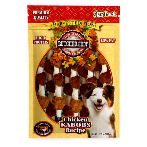 A 35-pack bag of Butcher Shop Harvest Edition Chicken Kabobs Recipe dog treats. The packaging features a yellow and red design with a photo of a brown and white dog on the lower right, and a clear window displaying the brown and white treat sticks inside.