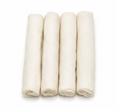 Four rolled sheets of pale cream-colored dog bones, arranged upright side-by-side on a clean white background.