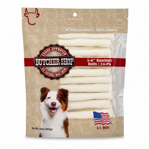 A package of butcher shop pet treats, featuring 5-6 inch rawhide rolls visible through a clear window on the front of the packaging. The packaging is beige with a dog illustration and a red logo.