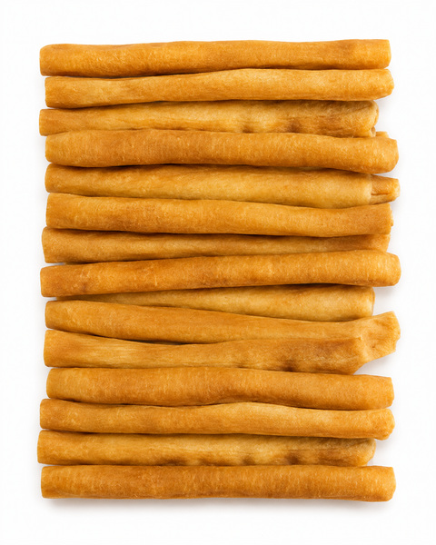 A stack of golden-brown, cylindrical breadsticks arranged vertically on a plain white background.