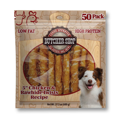 A 50-pack of Butcher Shop natural dog treats in a clear windowed bag. The packaging features a brown wood-grain pattern, red text highlighting 'Low Fat' and 'High Protein', a circular window showing golden-brown twisted treats inside, and a smiling brown and white dog on the lower right.