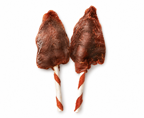 Two pieces of dried beef jerky shaped like arrowheads on white and red striped lollipop sticks, isolated on a white background.