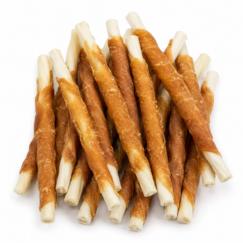 A pile of dog chew treats made from rolled brown strips with white ends, photographed on a clean white background.